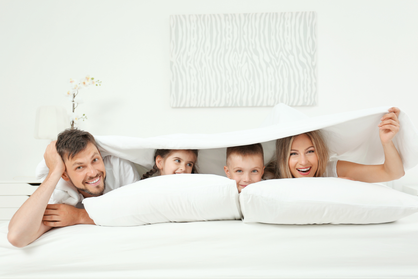 Family Lying on Bed in Hotel Room